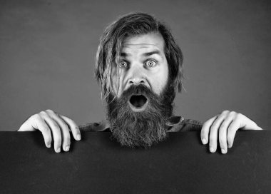 Kısıtlı teklif. Acele et. Berber dükkanı servisi. Reklam konsepti. Sakallı ve bıyıklı vahşi bir adam. bir iş arıyorum. Kopyalama alanı için yer. Boş kağıt levhalı sakallı adam şaşırdı.