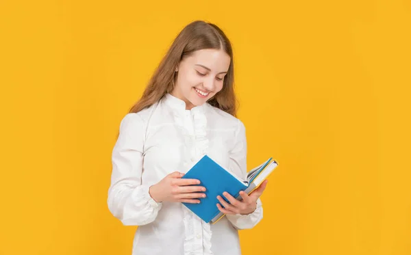 Felice teen girl in camicia bianca pronto a studiare fare i compiti leggere libro su sfondo giallo, lettore — Foto Stock