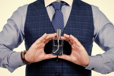 Kesilmiş adam parfüm şişesini tutuyor, kokuyor.