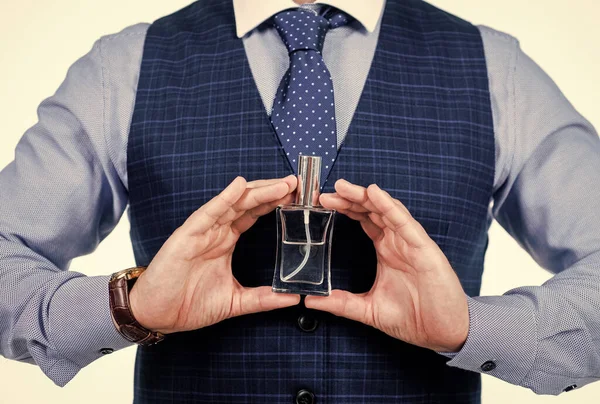 Kesilmiş adam parfüm şişesini tutuyor, kokuyor.