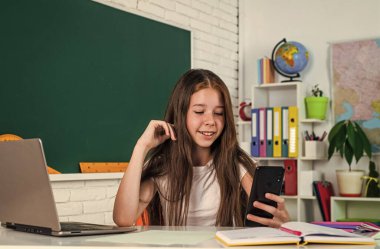 Akıllı telefonlu, çevrimiçi eğitimli bir kız.