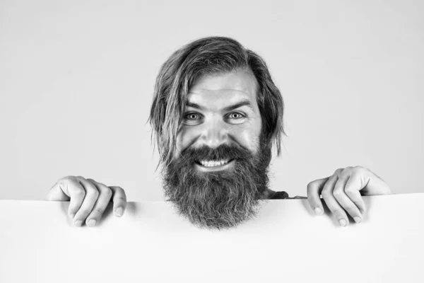 I am so happy. brutal man with beard and moustache. search for a job. place for copy space. happy bearded man with empty paper sheet. barbershop service. concept of advertisement — Stock Photo, Image