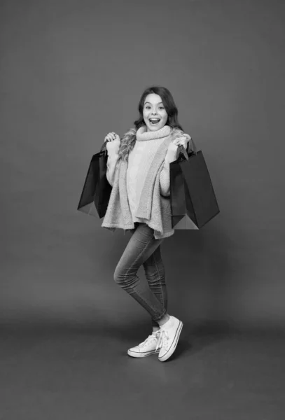 Ευτυχισμένο μικρό shopaholic με εμφάνιση μόδας μεταφέρουν τσάντες ψώνια κόκκινο φόντο, shopaholism — Φωτογραφία Αρχείου