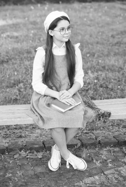 Elegant schoolgirl child girl study with book in park, french student concept