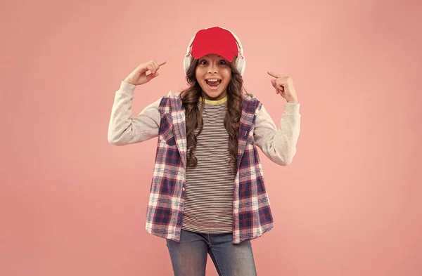 Chica adolescente feliz en gorra y auriculares. estilo casual de moda infantil. niño alegre escuchar música. —  Fotos de Stock