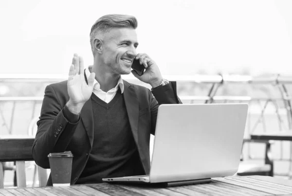 Gelukkig zakenman geven hand saluut gebaar praten op mobiele telefoon in internet cafe buiten, groet — Stockfoto