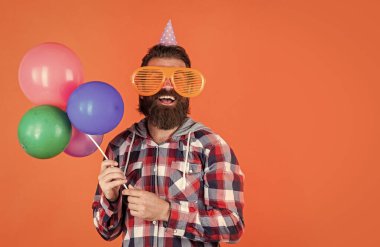 Havalı saç stili olan şık sakallı adam kareli gömlek giyer parti balonları, yıldönümü