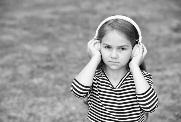 Serious cute child listen to music playing in headphones summer landscape outdoors, sound, copy space — Stock Photo, Image