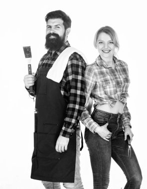 Aile barbeküye hazırlanıyor. Sakallı hippi ve kız ızgara çatal bıçaklarını beyaz arka planda tutuyorlar. Piknik ve barbekü. Arka bahçe barbekü partisi. Birlikte yemek pişirmek. Temel barbekü yemekleri.