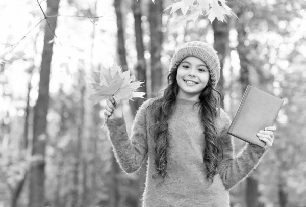 Heureux petit enfant tenir livre scolaire collecte feuilles d'automne dans le parc d'automne à l'extérieur, bibliothèque — Photo