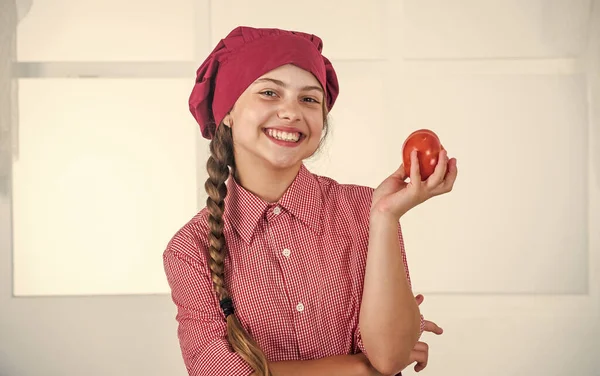 シェフの制服を着た10代の女の子の笑顔野菜、トマト — ストック写真