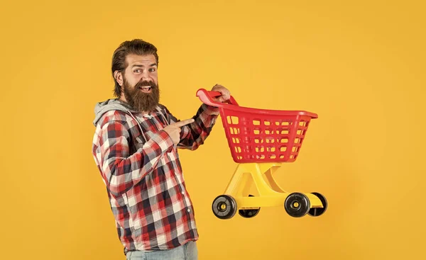 Mature handsome man in checkered shirt carry shopping cart, buy — Stock Photo, Image