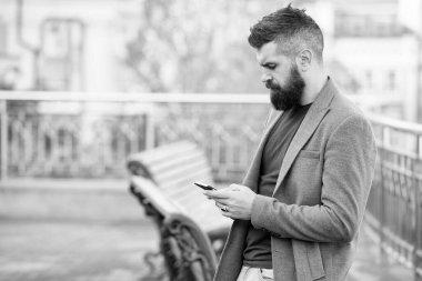 Meşgul hipster, dışarıdaki mobil internet ve e-posta kullanarak akıllı telefondan elektronik posta almış.