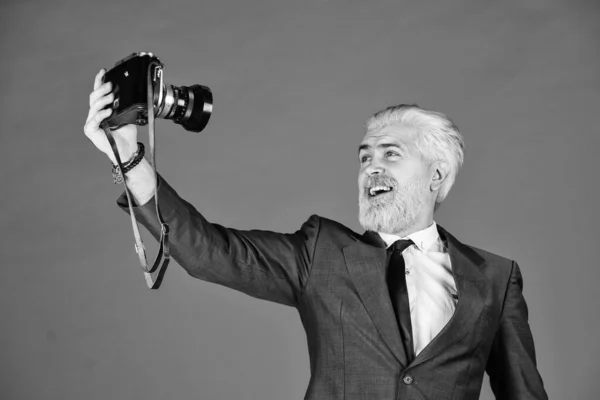 Hombre manteniendo el blog de moda. fotógrafo profesional hacer foto selfie. captura resultado del salón de peluquería. cámara vintage. feliz hombre de negocios mantenga cámara retro. hombre maduro teñido barba y cabello —  Fotos de Stock