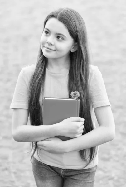 Ragazzo premuroso che tiene il libro. bambina che pensa all'aperto. istruzione scolastica nella vita moderna. Torniamo a scuola. teen girl ama leggere. taccuino per scrivere ricordi. bambino con diario scolastico — Foto Stock