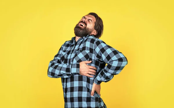 Жорстокий бородатий чоловік зі стильним виглядом відчуває біль у спині, здоров'я — стокове фото