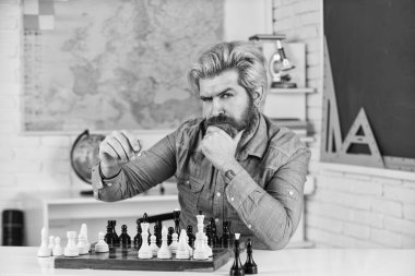 Satranç Federasyonu. Okul panosu eğlencesi. Öğretmen antrenman dersi alıyor. Eğitim konsepti. Olgun bir adam entelektüel oyun oynuyor. Akıllı adam satranç oynar. Satranç taşlı satranç tahtası. turnuva stratejisi