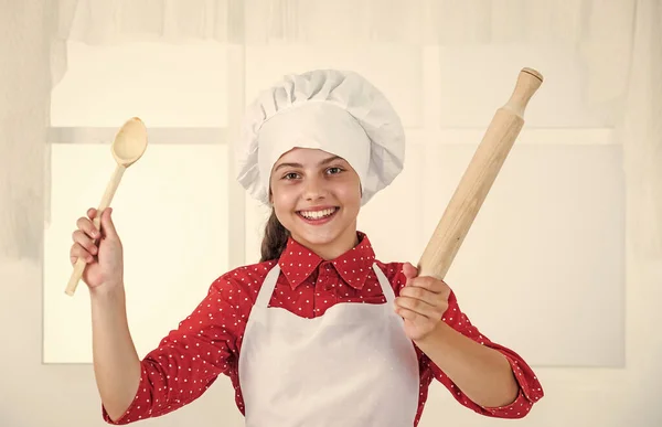 Gelukkig kind meisje in koken hoed en schort in keuken, chef-kok — Stockfoto