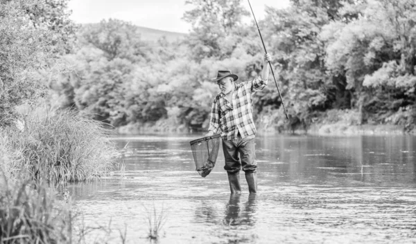 Pensionamento. uomo maturo pesca a mosca. uomo cattura il pesce. pescatore con canna da pesca. hobby e attività sportive. Pothunter. Pescatore barbuto in pensione. Esche di trota. weekend estivo. Grande gioco di pesca — Foto Stock