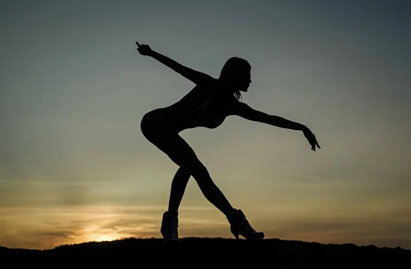 Een ballerina. vrouw silhouet op lucht achtergrond. gevoel van vrijheid. vrouwelijk silhouet bij zonsondergang. vrouw dansen in zonsopgang. Een donkere figuur van een danser. Dansen in de avond. schaduw en schaduw — Stockfoto