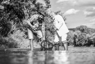 En iyi hafta sonuydu. İki erkek arkadaş birlikte balık tutuyor. Yakalama ve balık tutma konsepti. Mutlu balıkçı arkadaşlığı. Emekli baba ve olgun sakallı oğul. İş adamının uçan balık hobisi. emeklilik balıkçılığı