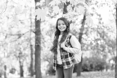 Sonbahar çocuk modası. İlham için romantik bir sezon. Mutlu çocukluk. Okula dönüyorum. Sırt çantalı genç kız parkta yürürken rahatlıyor. Sonbahar güzeli. Ormanda günün tadını çıkar.