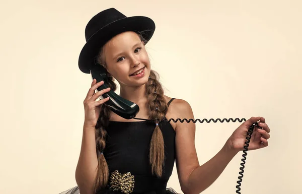 Ze luistert. nieuwe technologie. tiener meisje in hoed spreken over de telefoon. Retrofoon. Gelukkige jeugd. Hij heeft een telefoongesprek. communicatie in het moderne leven. kind met ouderwetse vintage telefoon — Stockfoto