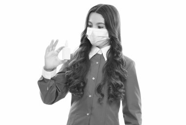 Çocuk burun spreyi kullanıyor. Burun akıntısı koronavirüs semptomu. Grip salgını terapisi. Semptomatik tedavi. Virüs salgını riski var. Çocuk etkili ilaçlar kullanıyor. Maskeli kız burun damlası tutuyor.