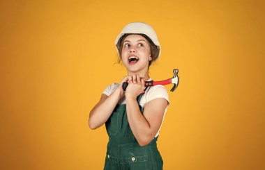 Arabanı inceliyorum. Çocuk inşaat alanında kask takıyor. İnşaat aletleri çekiçli genç kız müteahhit. Çocuk tamir işiyle uğraşıyor. Atölyede yenileme konsepti. meşgul profesyonel marangoz