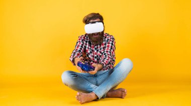 Yeni teknolojileri test ediyoruz. Sanal gerçeklik gözlüğü takan acımasız bir adam. Oyun konsolu. Adam kablosuz internet gözlüğü takıyor. VR kulaklıklı adam. hipster modern teknolojiyi kullanır. Dijital gelecek ve yenilik