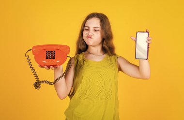 Çocuk retro ve modern telefonu konuşmak için bekletiyor.