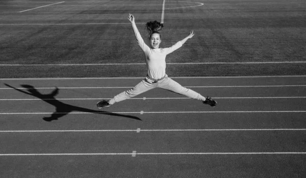 Meisje kind sprong hoog buiten op stadion arena, energie — Stockfoto