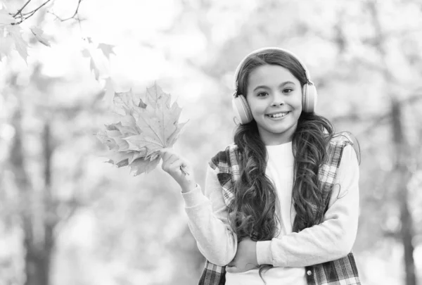 So schön. Herbstliche Kindermode. Inspiration. glückliche Kindheit. zurück zur Schule. Mädchen mit Ahornblättern entspannen im Park. Herbstschönheit im Wald. Musik im Kopfhörer genießen. Online-Bildung und E-Learning — Stockfoto