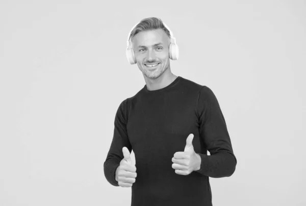 Alleen de beste. muziek en digitale technologie. ebook en elearning. Een ongeschoren man in een headset luisterliedje. muzikale app afspeellijst. draadloos apparaat van hoge kwaliteit. gelukkig man het dragen van oortelefoons show duim omhoog — Stockfoto