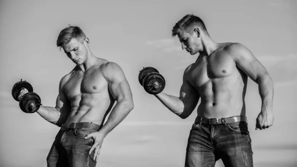 Adding weight on bar. Try to lift more than last time. Muscular twins. Men brothers muscular guys sky background. Strong muscular athlete bodybuilder. Attractive twins. Sexy torso attractive body — Stock Photo, Image