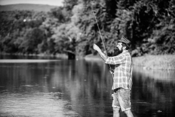 ¡Qué pez! hombre barbudo maduro con pescado en caña. pesca de caza mayor. relajarse en la naturaleza. pesca hipster con cuchara-cebo. pescador exitoso en el agua del lago. pasatiempo peces mosca. Actividad de verano —  Fotos de Stock