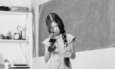 Bilimin geleceğine bakıyorum. Okula dönüyorum. Biyoloji eğitimi. Okul laboratuarı. Modern teknoloji. Laboratuvar matarası olan küçük bir kız. Mikroskopla fen dersi. kız tüple kimya okuyor.