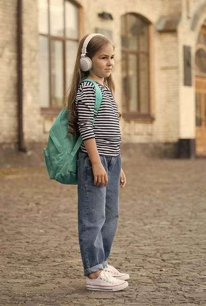 Elkötelezi magát az utazás mellett. A kislány hátizsákot hord fejhallgatóban a szabadban. Nyári utazás. Nyaralás. Utazási cél. Utazás és utazás. Felfedezés és kaland. Légy utazó! — Stock Fotó