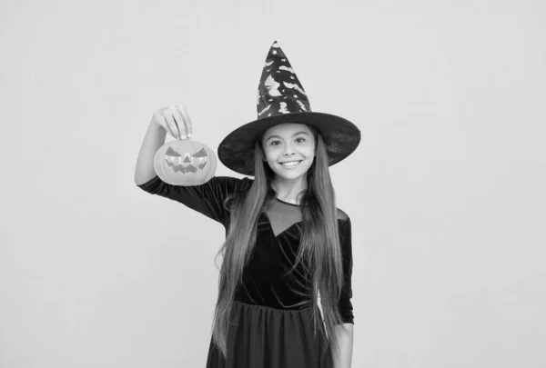 Ünnepelni az ünnepeket. Töklámpás. Halloweeni boszorkány lány. Boldog gyermekkort. tinédzser gyerek boszorkánykalapban. Vidám gyerek kezében tök. Karnevál jelmezbál. Csokit vagy csalunk. Egy eladott szörny. — Stock Fotó
