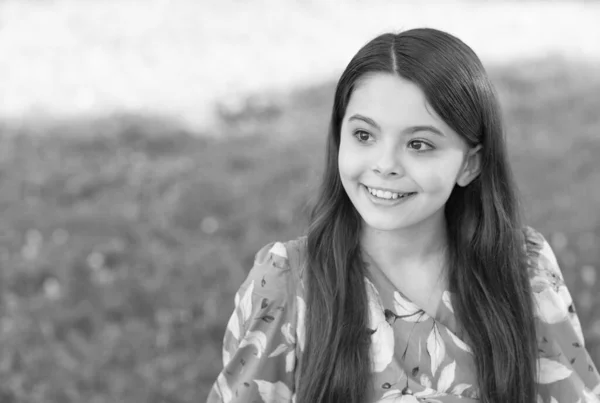 小さな女の子長い髪ファッショナブルなドレスリラックスで公園晴れた日の自然背景、夏休みのコンセプト — ストック写真