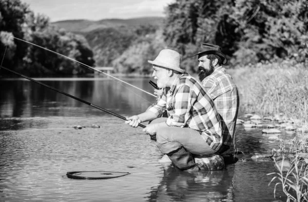 Vild natur. pensionerad pappa och mogen skäggig son. Glad yrkesfiskarvänskap. Två manliga vänner som fiskar tillsammans. flugfiske hobby män i rutig skjorta. Pensioneringsfiske. Fångst och fiske — Stockfoto