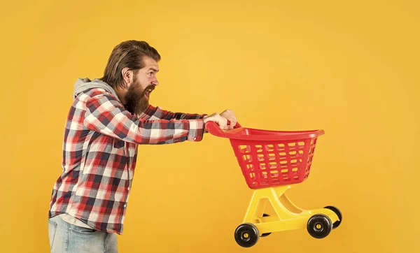 Cara barbudo elegante com penteado na moda desgaste xadrez camisa segurar carrinho de compras, compra — Fotografia de Stock