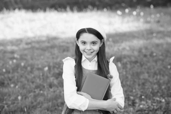 Kleines intelligentes Mädchen mit Buch im Freien sonniger Tag, anspruchsvolles Schulmädchenkonzept — Stockfoto