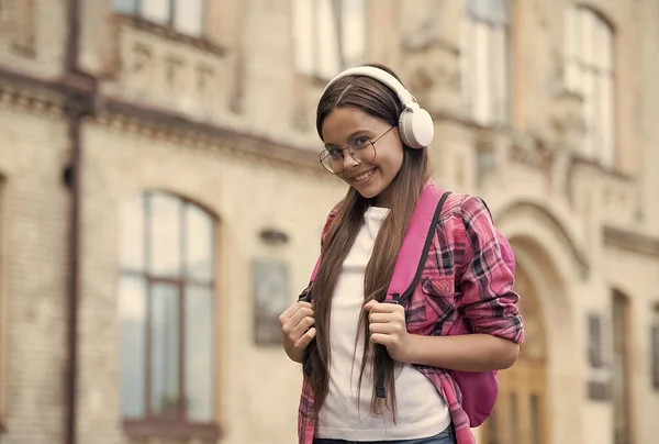 Chica feliz sonrisa escuchando la banda sonora en los auriculares modernos al aire libre, música, espacio de copia — Foto de Stock