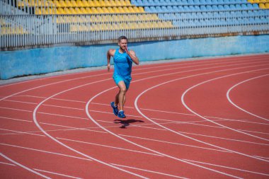 Stadyumda koşan kaslı bir koşucu.