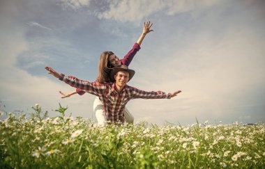 Aşık mutlu çift papatya çiçeği tarlasında rahat hisseder, kaygısız