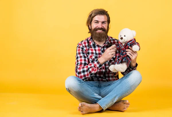 Conceito de amizade. brutal maduro hipster homem jogar com brinquedo. Feliz aniversário. estar de bom humor. Feliz Dia dos Namorados. homem barbudo alegre segurar ursinho. masculino sentir brincalhão com urso. espaço de cópia — Fotografia de Stock