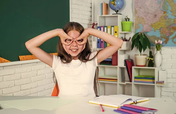 Usmívající se teen dívka dělat obličeje ve škole třídě, baví — Stock fotografie