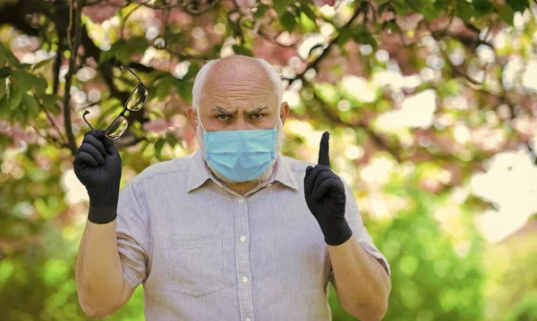 Recomendo vivamente. use máscara no parque sakura rosa florescente. homem em sakura em máscara protetora. cheirar flores florescendo em quarentena coronavírus. observar precauções durante a pandemia. vida saudável — Fotografia de Stock