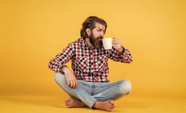 Sadece bir yudum. Yaşam tarzı konsepti. Kahveli yakışıklı hippi. O bir kahve molası veriyor. Fincandan su içen yakışıklı bir yetişkin. Bir fincan kahve ya da çay.